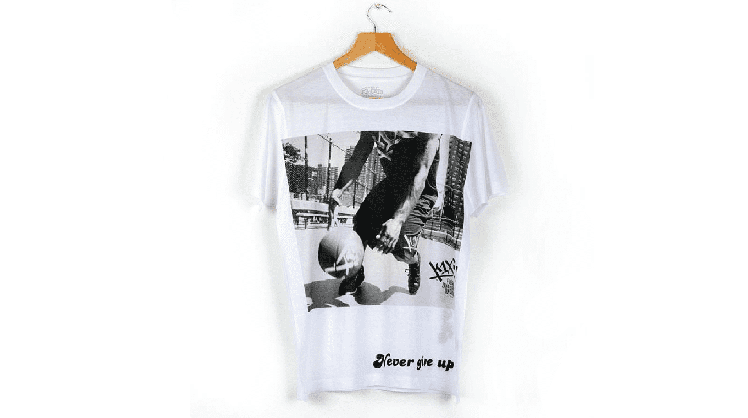 "Custom printed white cotton t-shirt hanging on a wooden hanger, featuring a vintage black and white basketball action photograph print and 'Never give up' text typography."
