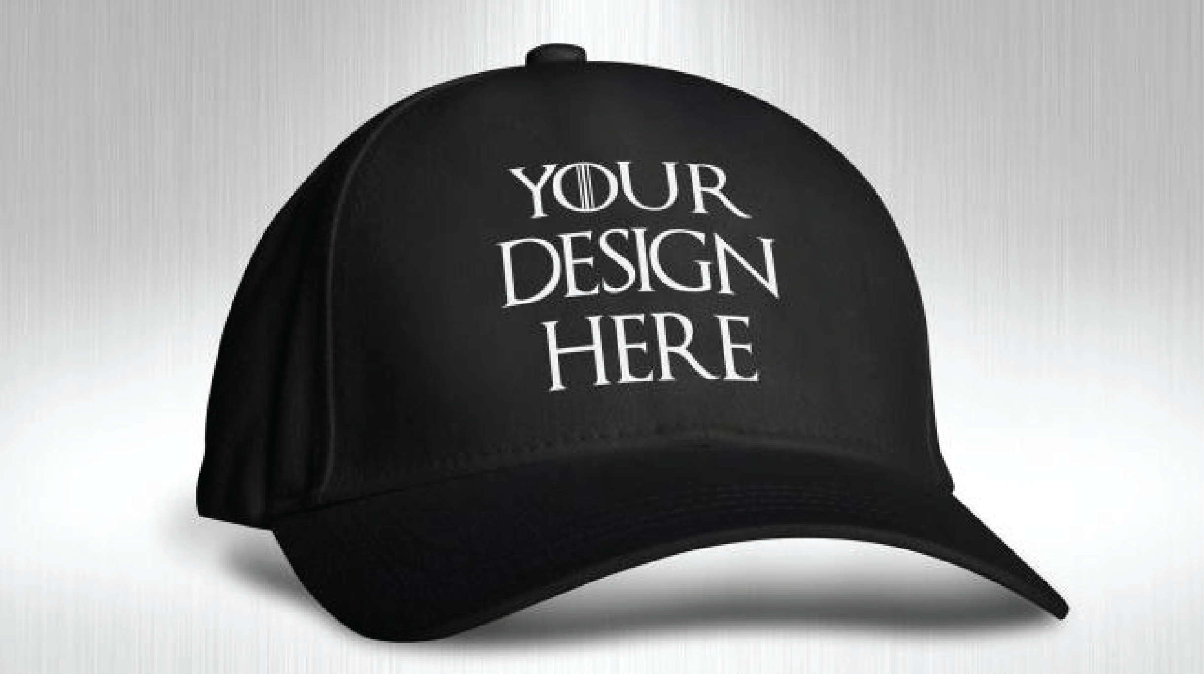 "Premium black structured baseball cap mockup with white stylized text placeholder that says 'YOUR DESIGN HERE' against a metallic silver brushed background."