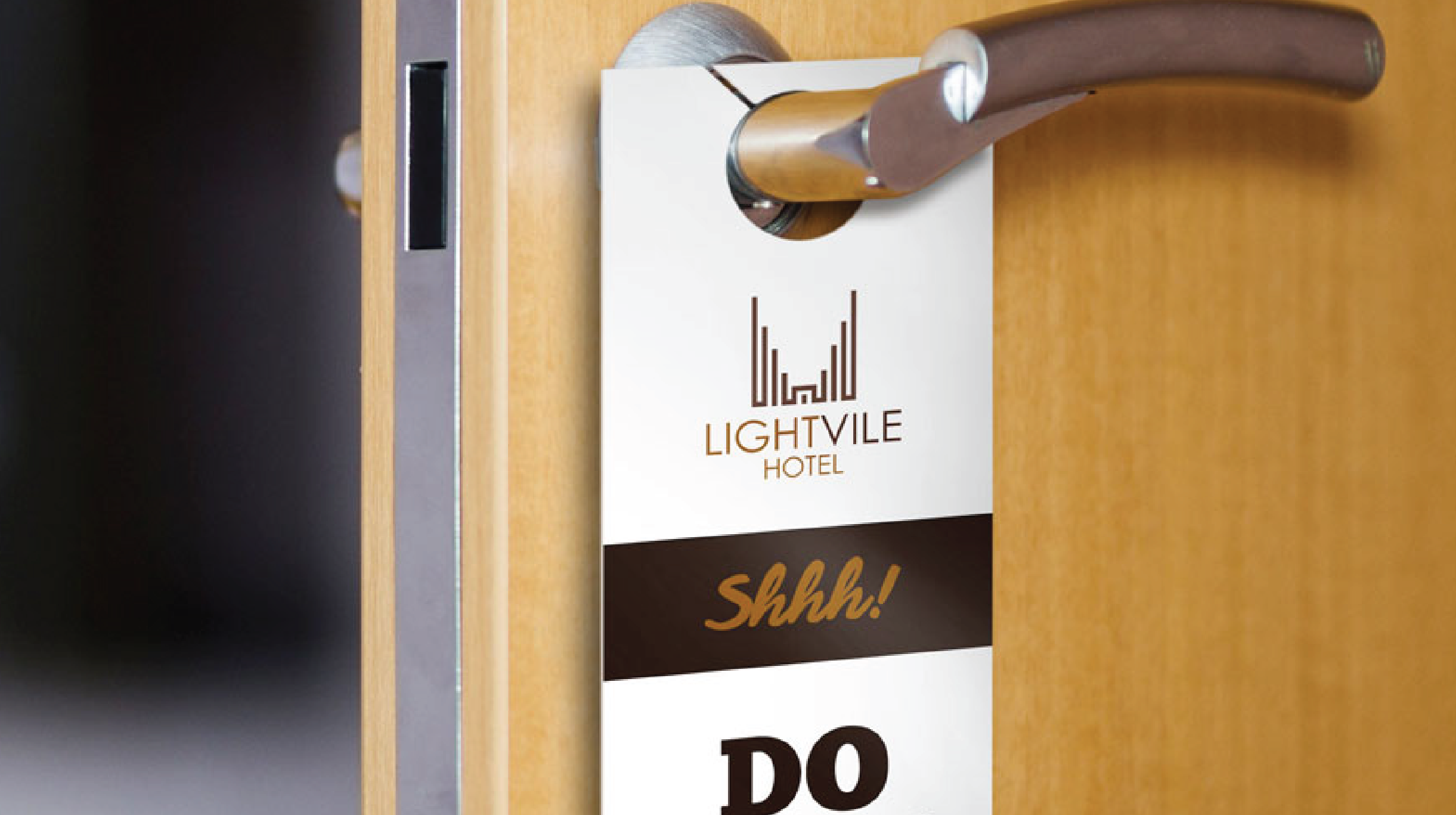 "Premium custom printed hotel door hanger hanger template hanging on a metallic door handle, featuring the 'LIGHTVILE HOTEL' logo and a 'Shhhh! DO NOT DISTURB' message."