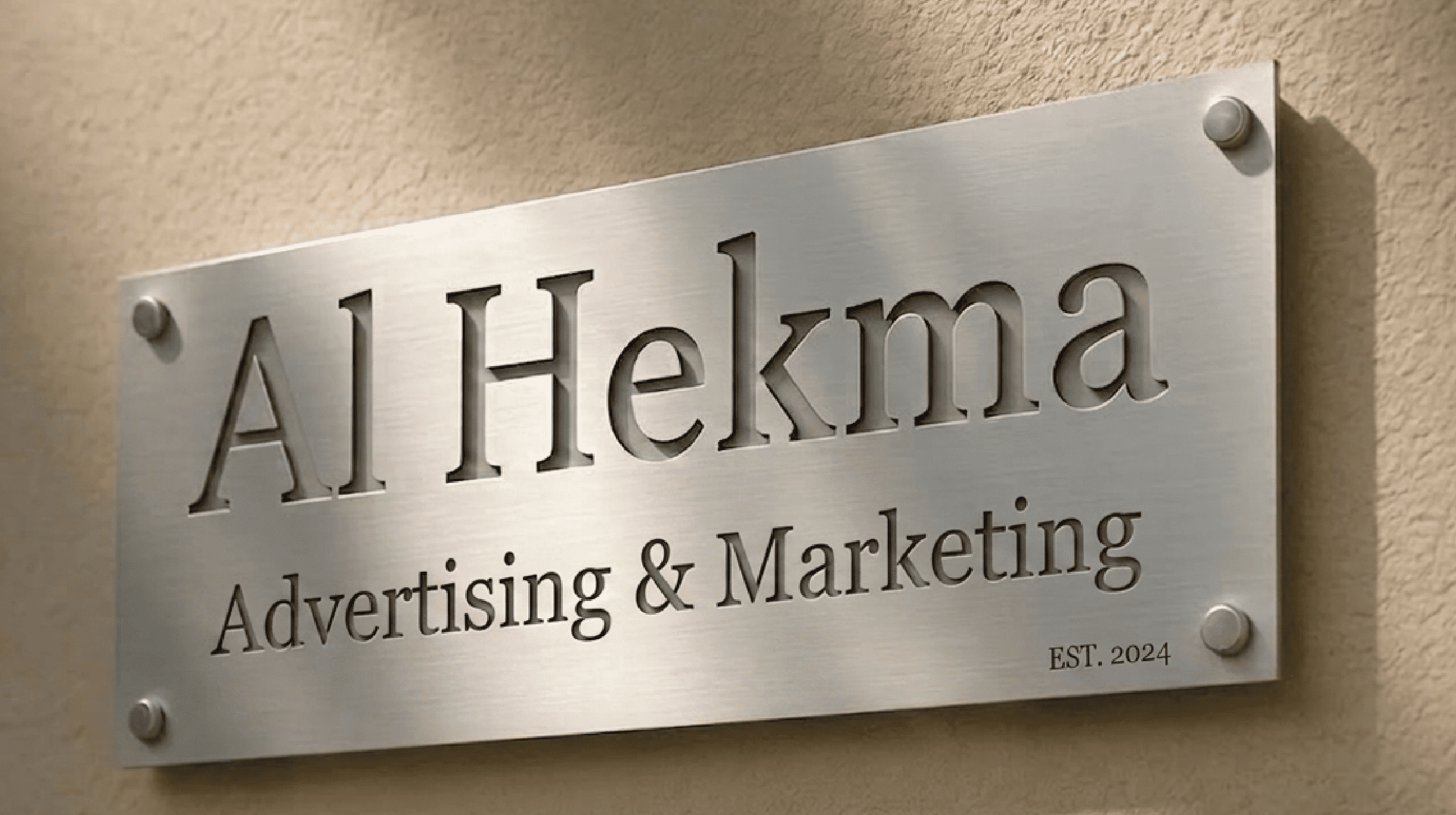 "Premium brushed stainless steel wall sign for Al Hekma Advertising & Marketing with professional laser-cut lettering."