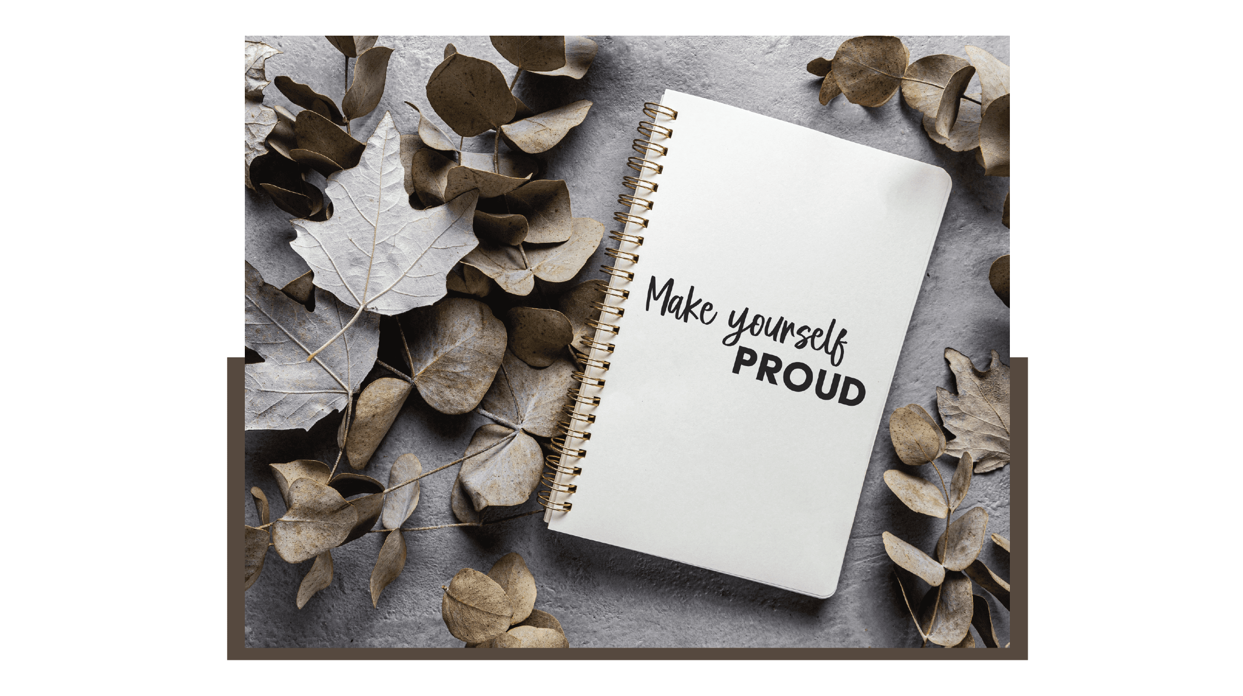 "Custom spiral notebook with 'Make yourself PROUD' text printed on the cover, arranged with dry autumn leaves on a textured grey background."